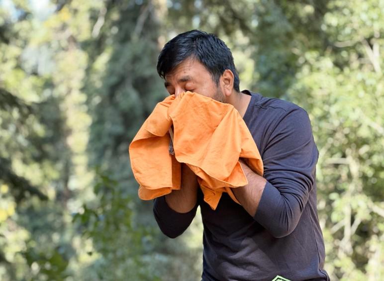 Using Sea to Summit Drylite Towel to wipe face during outdoor backpacking trip in forest