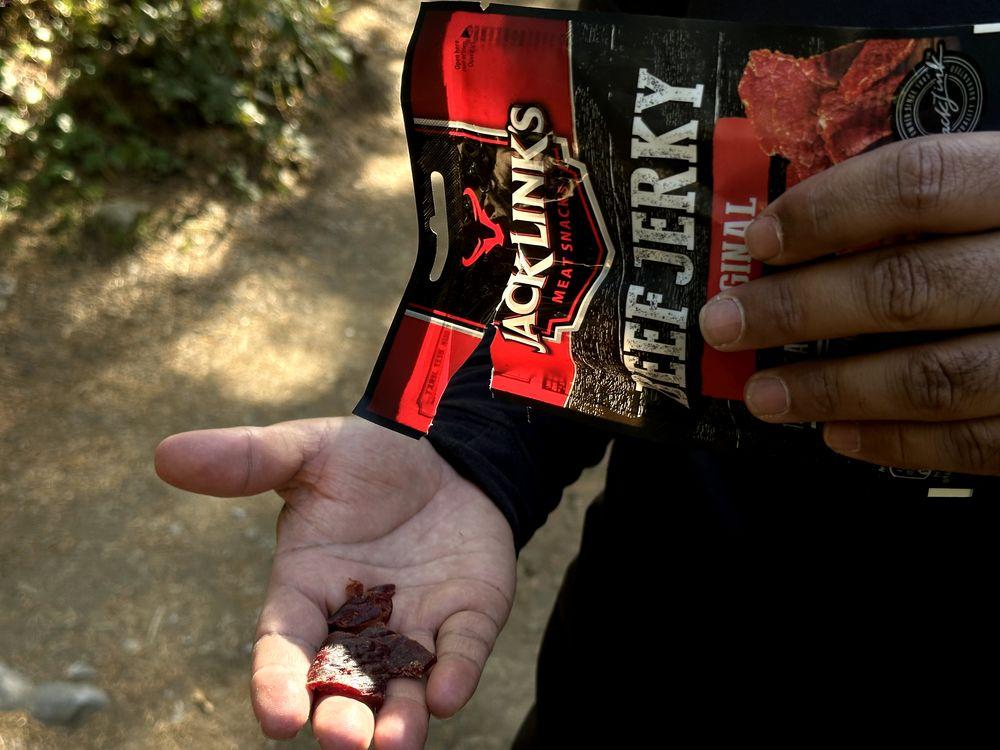 Eating beef jerky hiking snacks on the trail