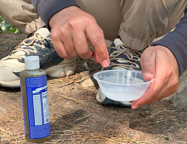 Mixing liquid soap with water while camping