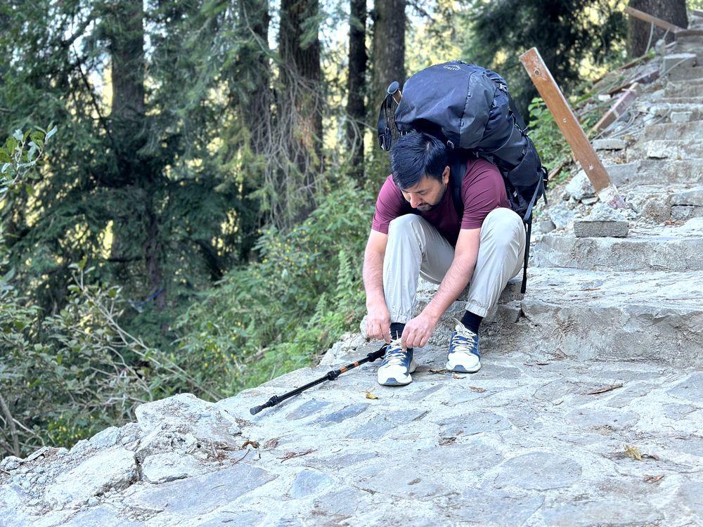 Osprey Rook 65 Hiking Bag (Sitting on trail adjusting shoe laces)