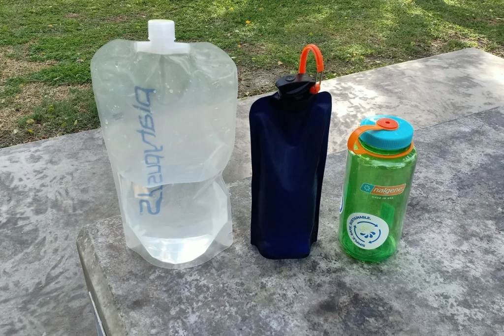Platypus Platy, Vapur soft bottle, and Nalgene Wide Mouth bottle compared on a table