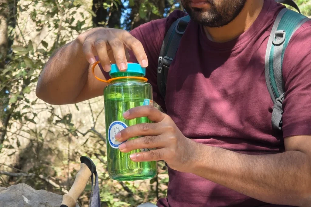 Tightening the cap on a Nalgene Wide Mouth water bottle during a hiking break
