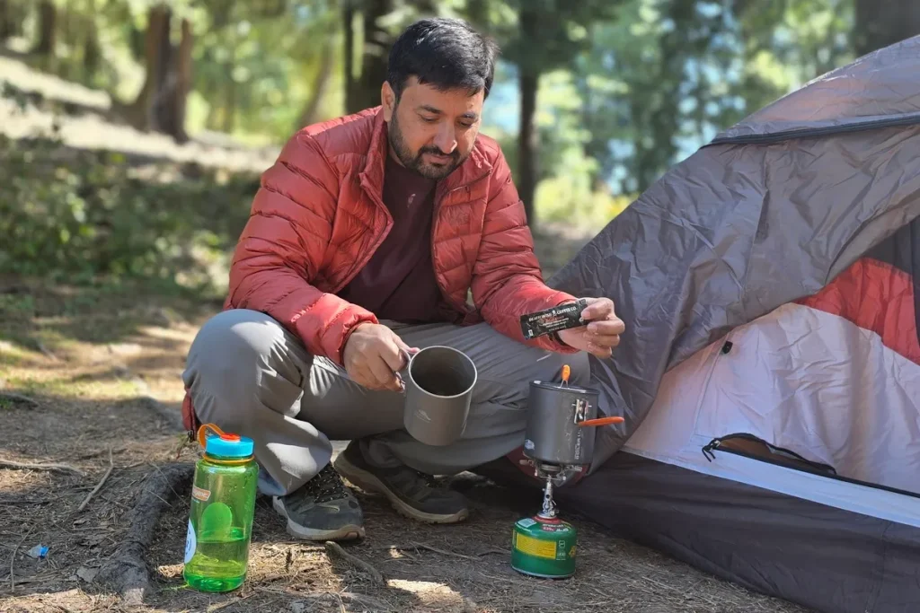 Nalgene Wide Mouth water bottle beside a tent and camp stove during a backpacking trip