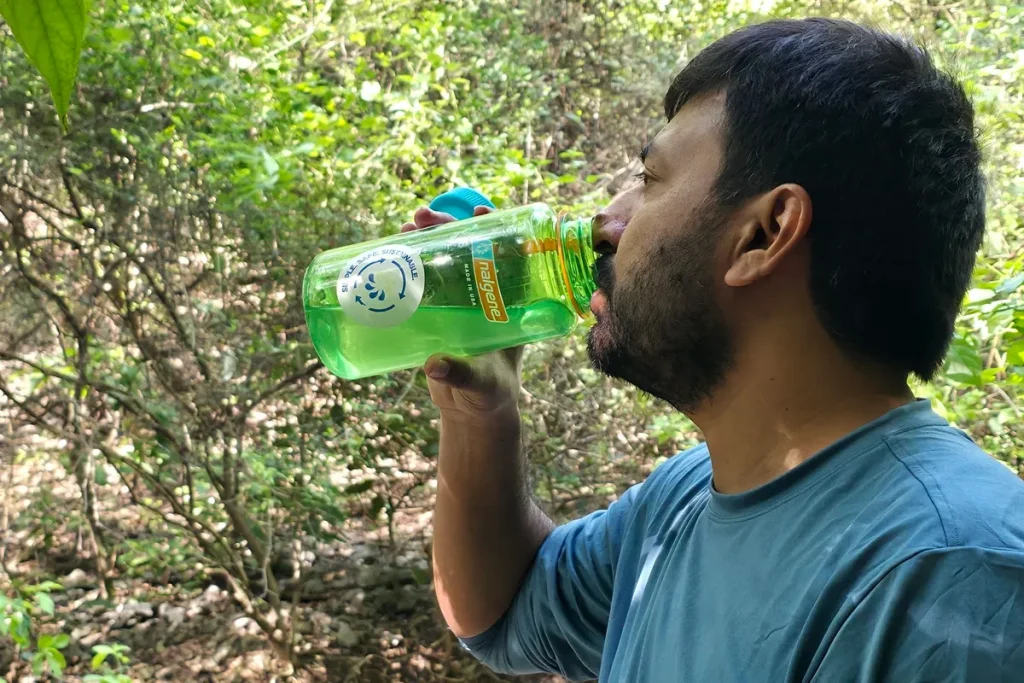 Drinking from a Nalgene Wide Mouth bottle during a taste and odor test on the trail