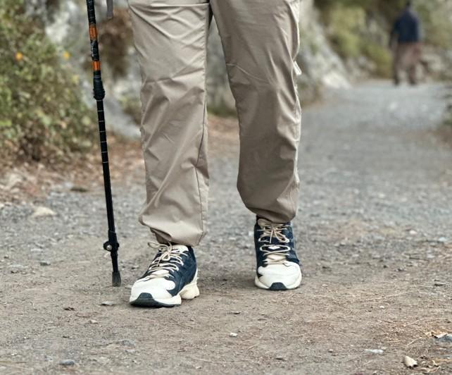 Proper trekking pole placement while hiking on an even trail