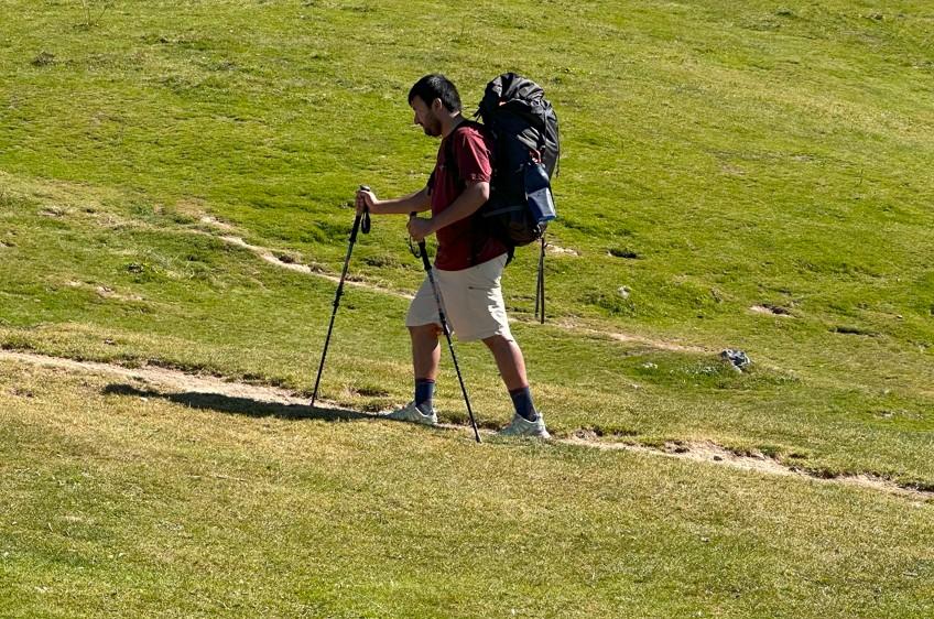 Demonstrating how to use trekking poles with heavy pack