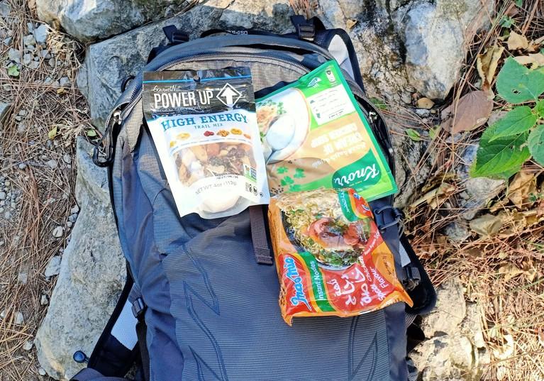 Favorite hiking snacks—trail mix, noodles, and  soup—next to my daypack