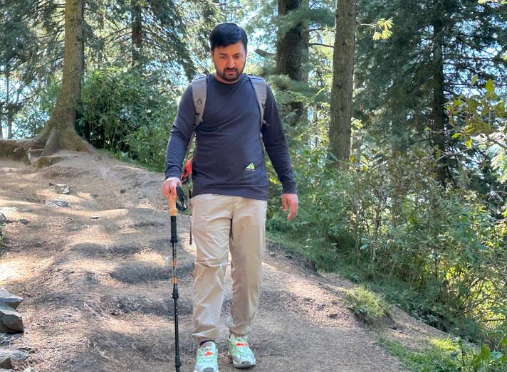 Enjoying an easy hike with trekking poles on a gentle forest trail.