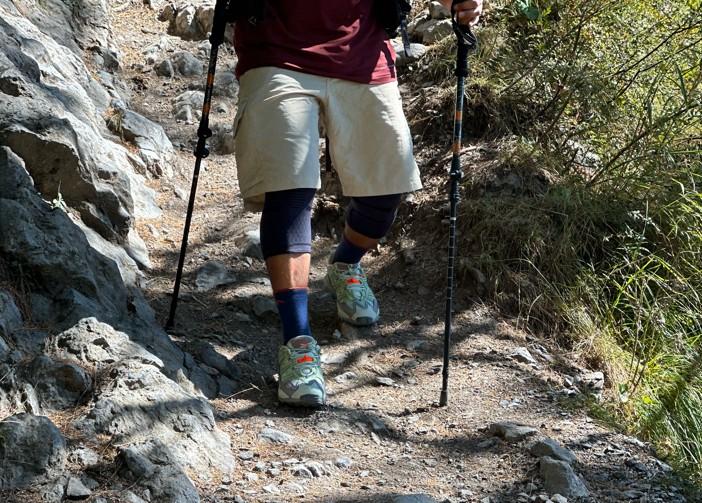 Demonstrating safe downhill hiking with trekking poles in rocky terrain