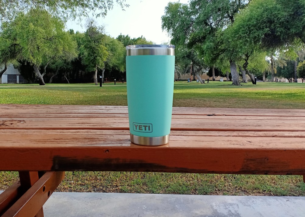 Turquoise YETI Rambler tumbler on an outdoor picnic table