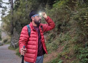 Outdoor headlamp: Hiker testing a headlamp (Black Diamond Astro 300) on the trail for a best headlamps for hiking and backpacking review